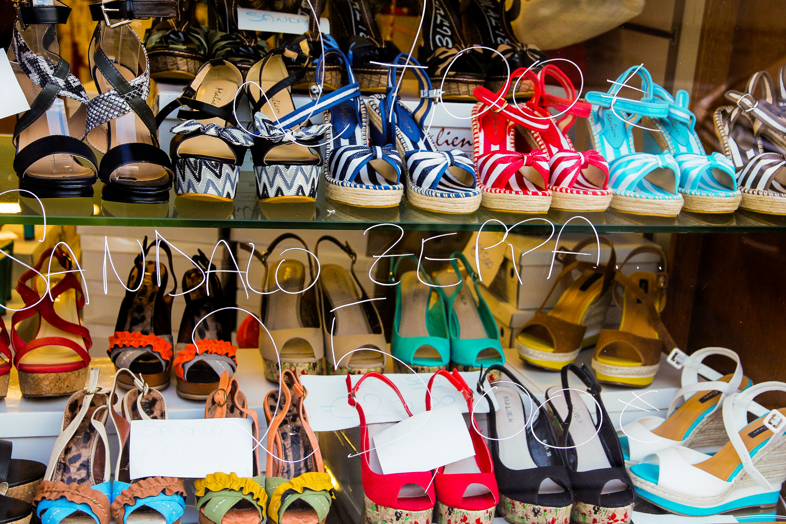 Auslage voller „sandalo zeppa" – Sommerschuhe in der Altstadtgasse